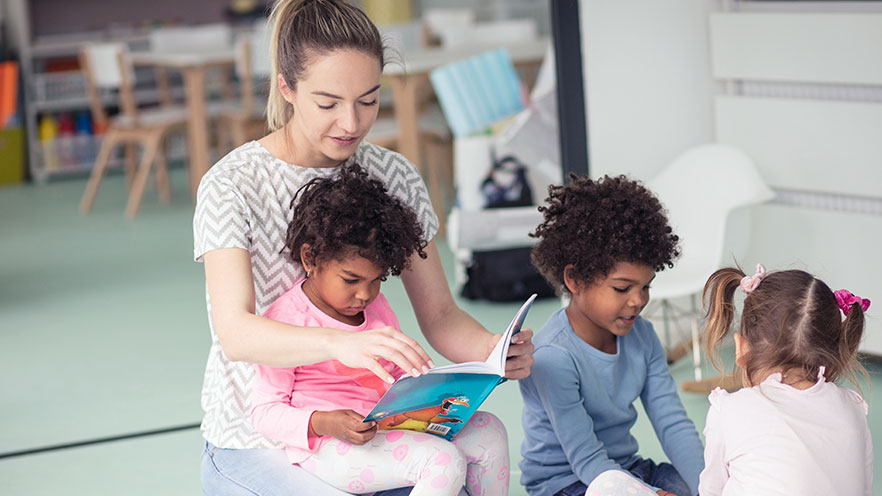 Childcare worker reading to children - Childcare Franchise Loans